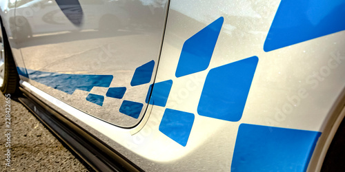 Blue decal on the exterior body of a white car