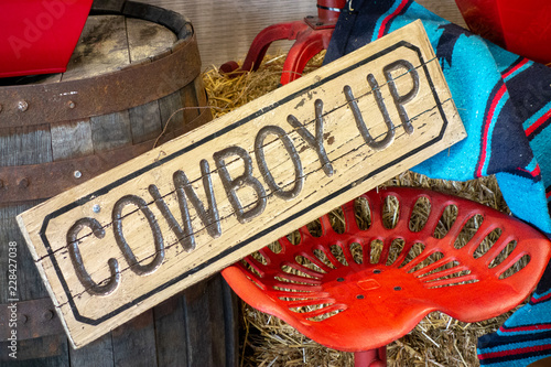 Western decor with Cowboy up sign and painted red vintage tractor seat