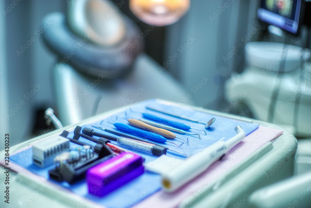 Selective focus of necessary dental equipment and working tool for dentist background chair and defocused medical office. cold and blue tones