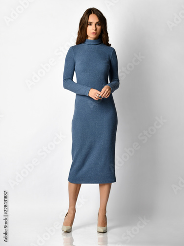 Young beautiful woman posing in new dark blue fashion winter dress on high hills full body 