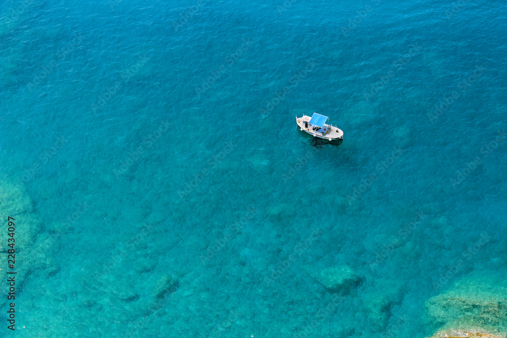 Naklejka premium Boat floating in blue green waters of the Mediterranean Sea in the Cinque Terre area of Italy seen from above