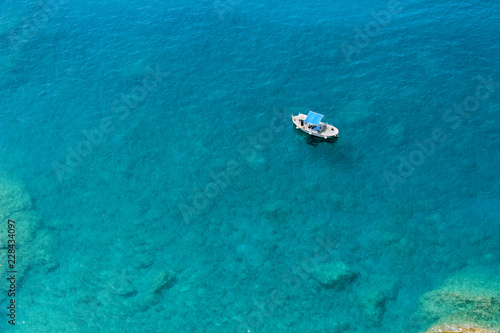 Boat floating in blue green waters of the Mediterranean Sea in the Cinque Terre area of Italy seen from above © aSculptor