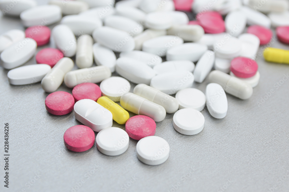 A bunch of colorful pills on a gray background.Medical topic A bunch of colorful pills on a gray background.Medical topic