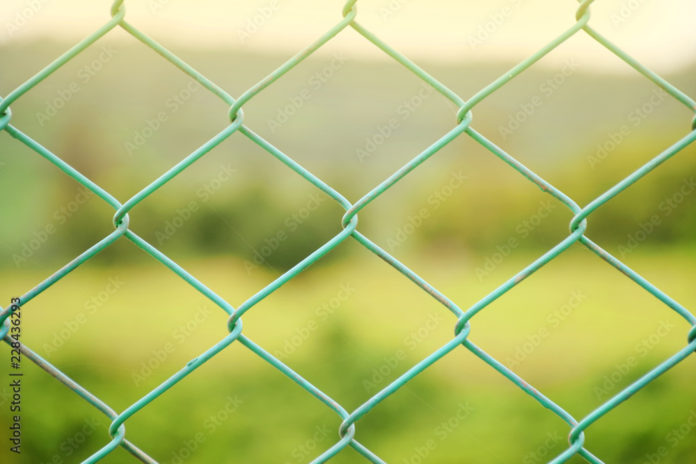 Fototapeta premium Steel fence on green field