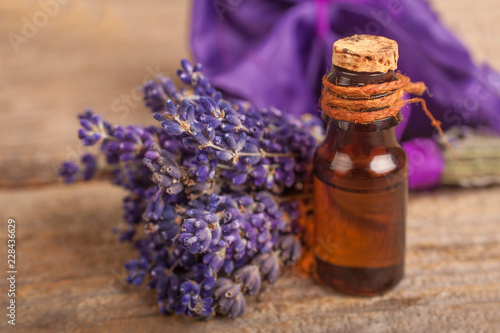 Essential lavender oil with a lavender flower on a rustic background