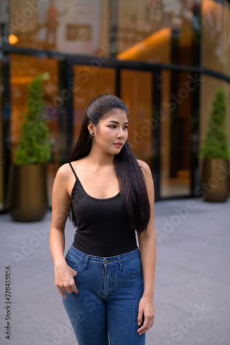 Young beautiful Asian woman exploring around the city
