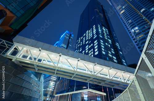 Low angle view of walkway bridge and skyscraper office building   night scene
