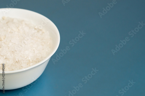 sea salt in a white Cup on a blue light background, place under the text