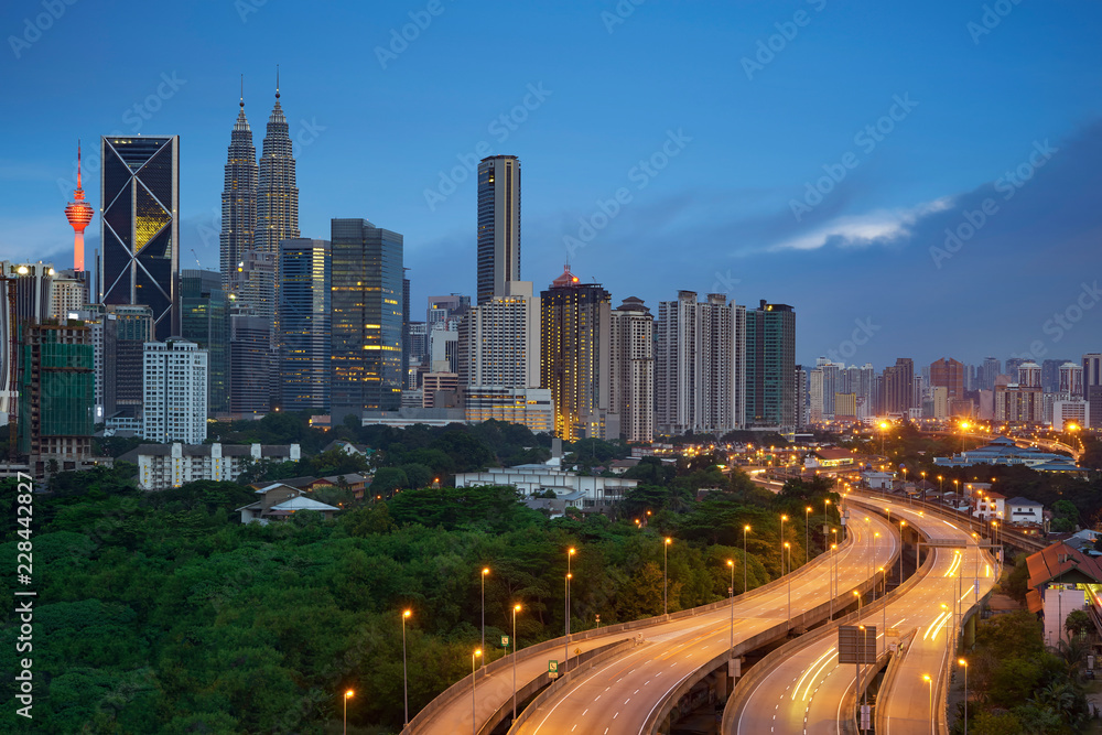 Kuala Lumpur night cityscape skyline with illuminated highway flyover road