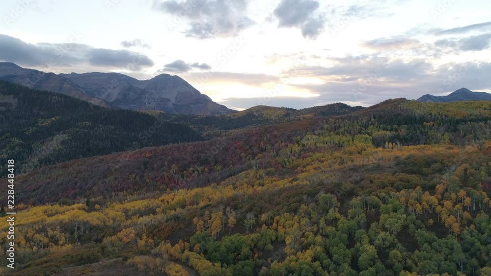 Fall color spanning over mountain landscape at sunset flying over the forest below. Fall color spanning over mountain landscape at sunset flying over the forest below.