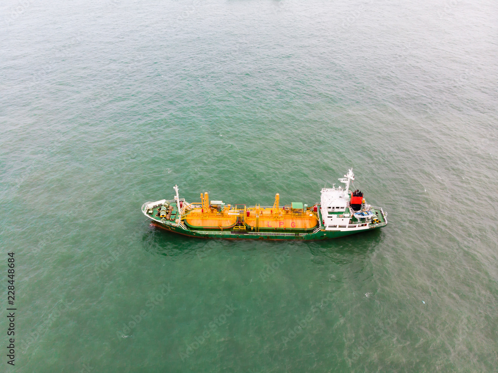 Fototapeta premium Aerial view of sea freight, Green,yellow oil tanker ship, Lpg, Cng at industrial estate Thailand / Crude Oil tanker to Port of Singapore - import export around in the world