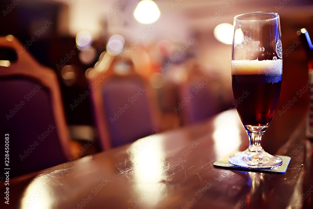 mug of dark beer in the interior of  pub / pint of beer with foam on a served table in  beer restaurant in Czech Republic