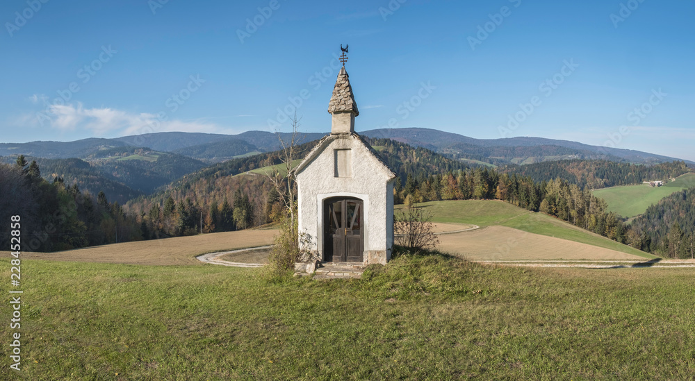 Chapel on the hill with panoramic view of mountain Pohorje in background, Slovenia Chapel on the hill with panoramic view of mountain Pohorje in background, Slovenia