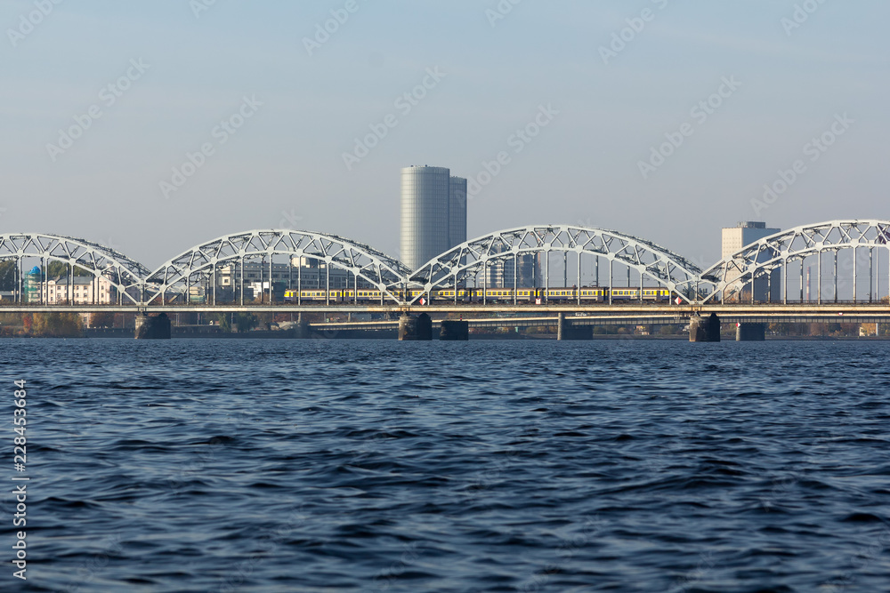 Naklejka premium Railway bridge in Riga over the Daugava River in the fall in October on a sunny day
