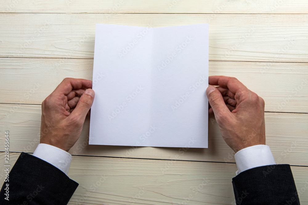 Obraz premium Mens hands holding empty white booklet