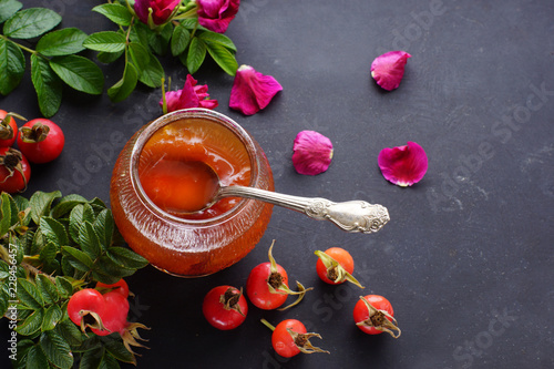 A jar of wild rose jam, top view, place for text