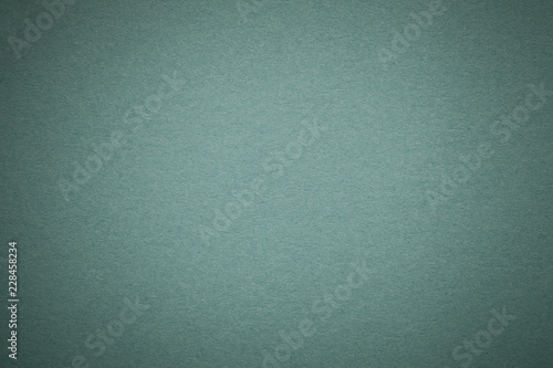 Texture of old light green paper background, closeup. Structure of dense steel cardboard.