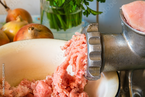 Old mincer and raw minced meat on rustic background close up photo