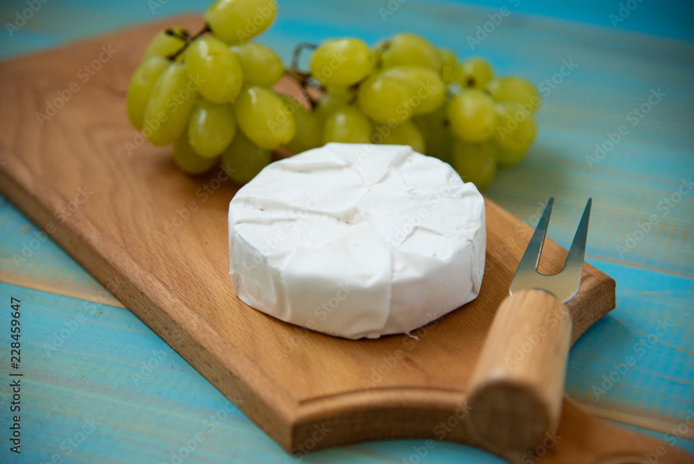 camembert, with a fork for cheese and grape