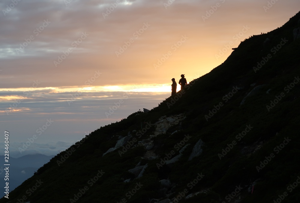 夕日を眺める登山者