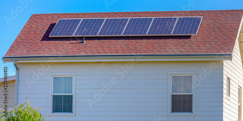 Solar panels mounted on the red rooftop of a home