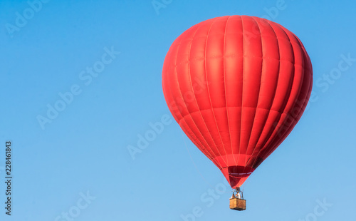 Red balloon in the sky. Aerostat. People in the basket. Fun. Summer entertainment. Romantic adventures.