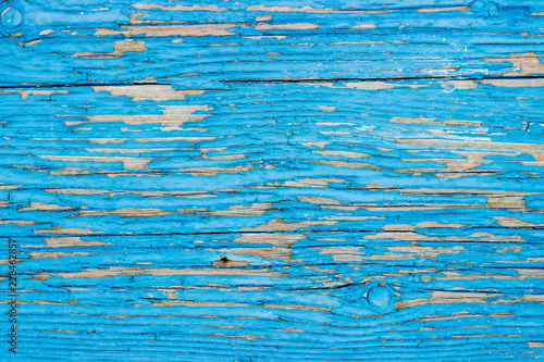 Close up of a old wooden door, teal blue paint peeling off; texture background