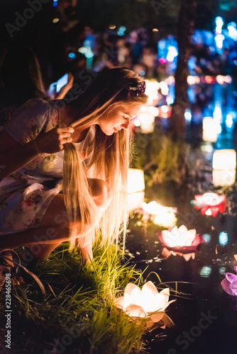 Young womant with chinese lanterns floating in lake photo