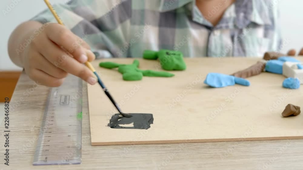 Child's hands playing colorful clay and paint on table. Development of fine motor skills of fingers and creativity, education.. Child's hands playing colorful clay and paint on table. Development of fine motor skills of fingers and creativity, education..