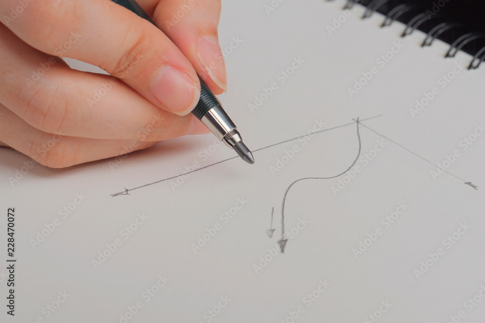 Hand holding pen and drowing graph on white sheet Hand holding pen and drowing graph on white sheet