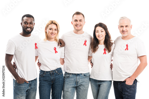 multiethnic group of people in blank white t-shirts with aids awareness red ribbons looking at camera isolated on white