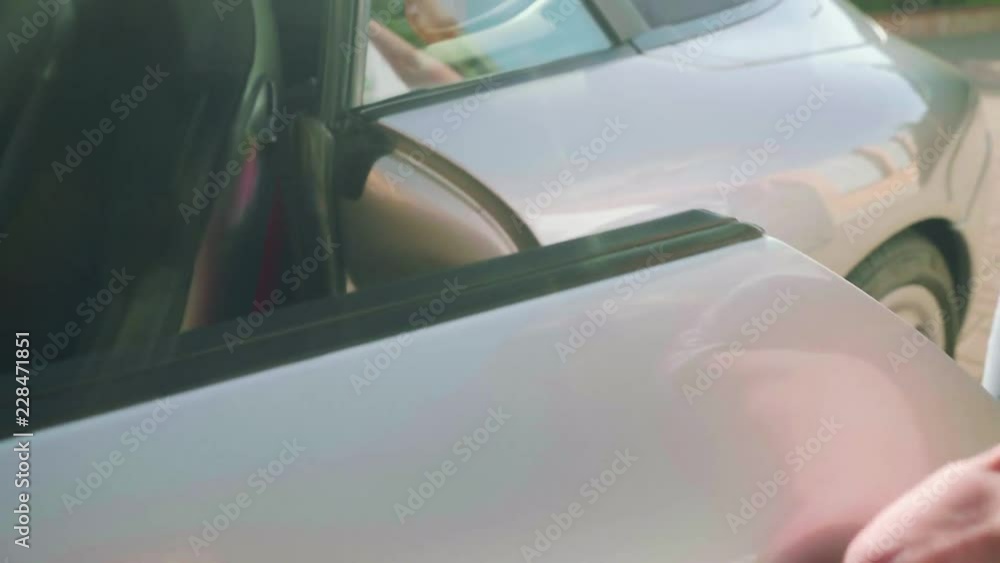 Man's hand slides on silver sport car and opens driver's door Man's hand slides on silver sport car and opens driver's door