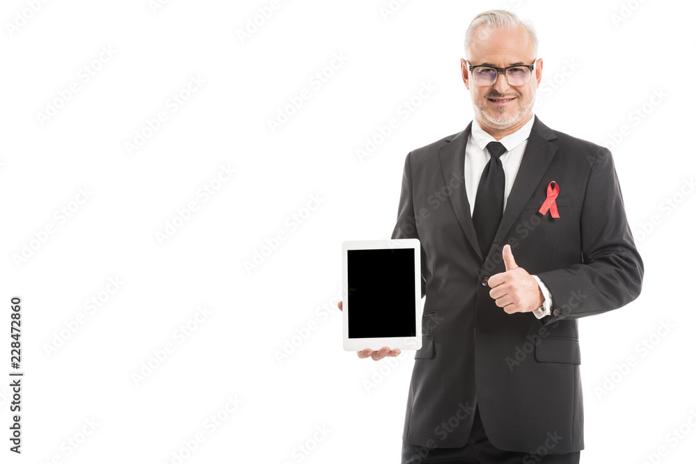 mature businessman in suit with aids awareness red ribbon holding tablet with blank screen and showing thumb up isolated on white mature businessman in suit with aids awareness red ribbon holding tablet with blank screen and showing thumb up isolated on white