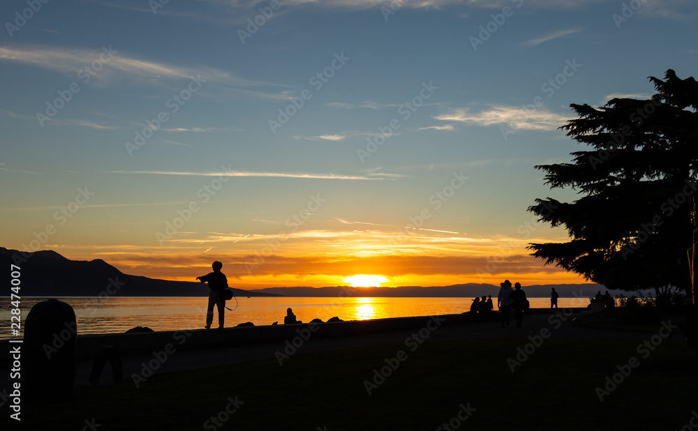 Fototapeta premium Sunset. Silhouette. People. Lake. Evening. Sky