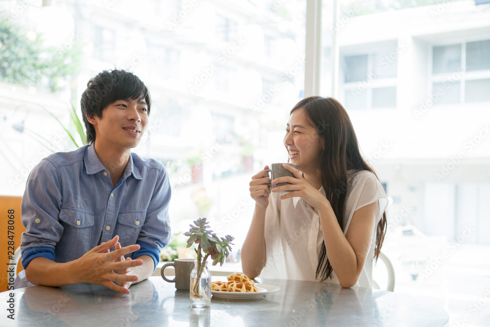 カフェでコーヒーを飲む20代男女 カフェでコーヒーを飲む20代男女