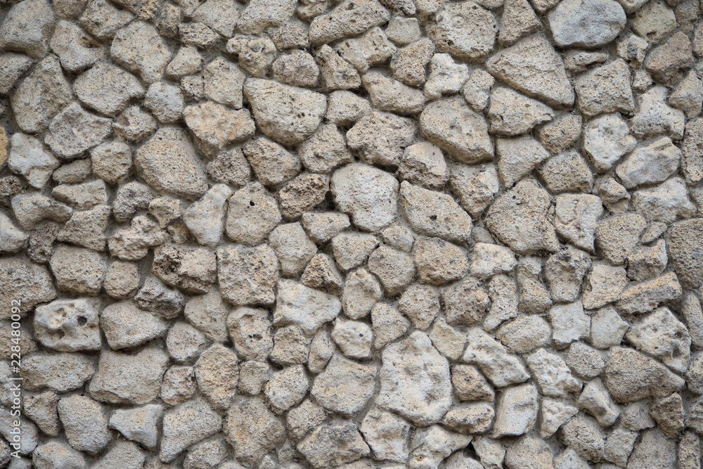The wall is made of grey natural stone. Abstract background.