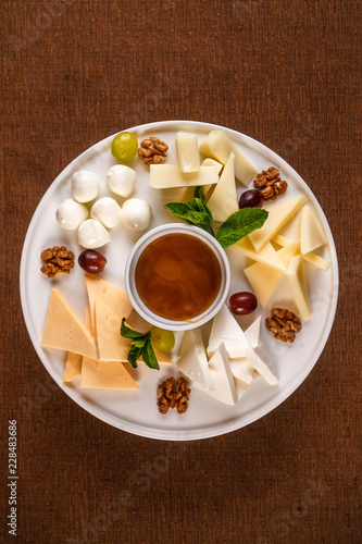 Cheese plate Assortment of various types of cheese and honey on white plate