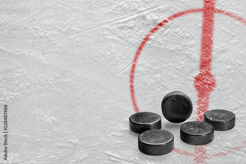 Fototapeta premium Pucks and a fragment of the hockey arena with a central circle