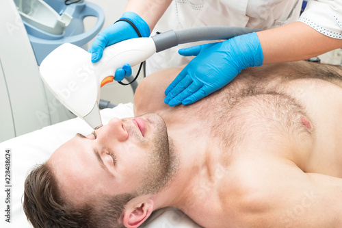 Man on the procedure of laser hair removal in the beauty salon