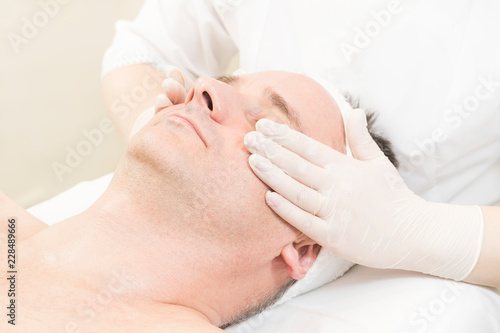 Man in the mask cosmetic procedure in spa salon. 