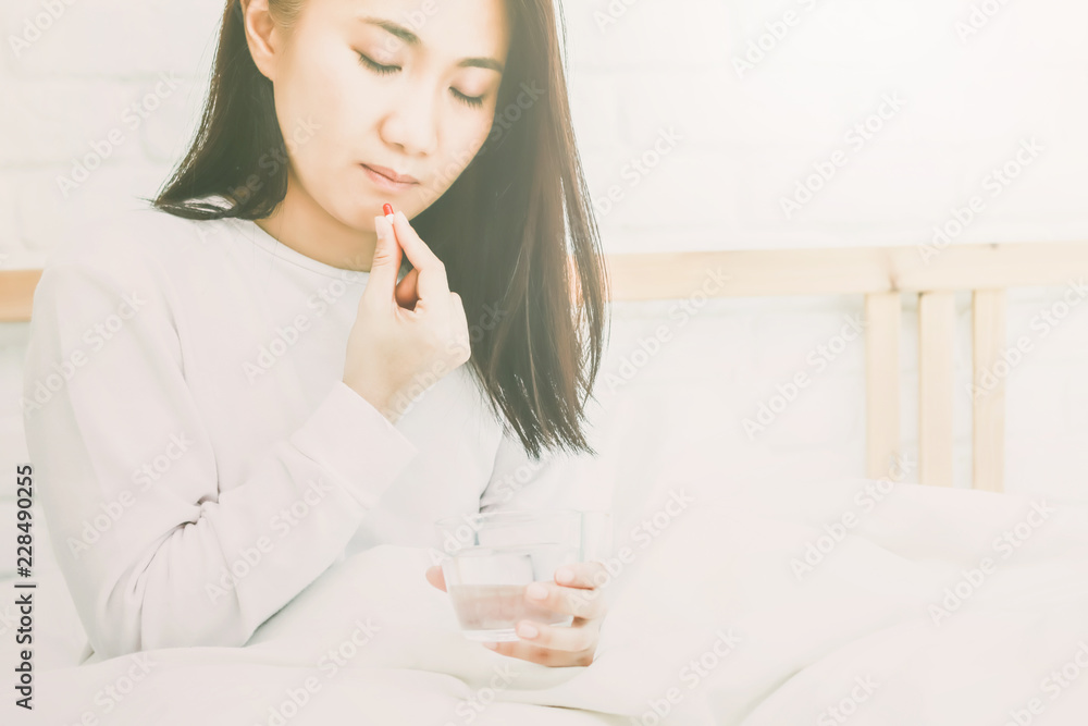 Asian women take a medicine on bed. Asian women take a medicine on bed.