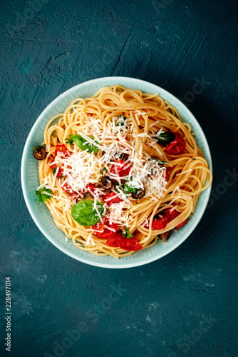 spagetti mit tomaten auf blauen untergrund
