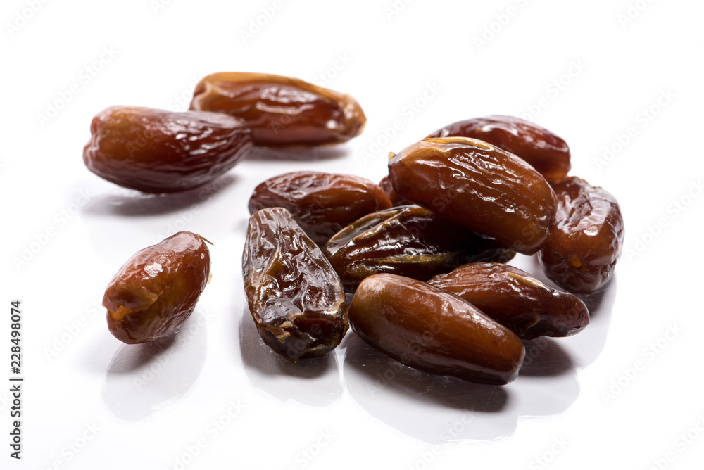 Close-up of pile dried, raw dates on white background Close-up of pile dried, raw dates on white background