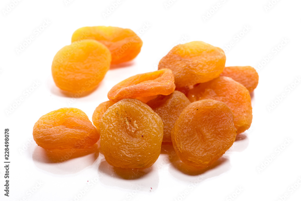 Close-up of pile dried, raw apricots on white background Close-up of pile dried, raw apricots on white background