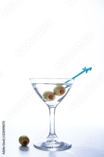 Martini cocktail liquor drink with the pickled olive isolated on white background