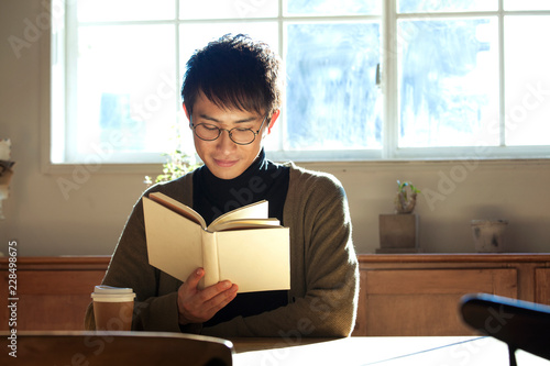 部屋で読書をする20代男性