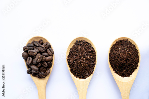top view wooden spoons filled with coffee bean and crushed ground coffee , on white background