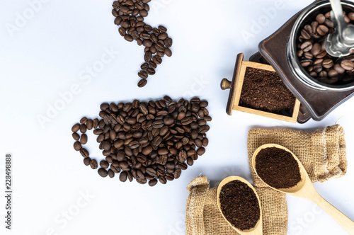 coffee beans in coffee cup shaped with wooden grinder and sack