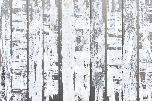 Close-up of vertical strips of white torn paper on a light gray metal background 