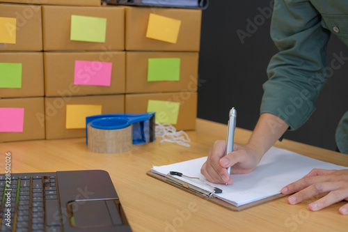 Fototapeta Naklejka Na Ścianę i Meble -  startup small business owner writing note. man seller working at home.  Online selling, e-commerce concept